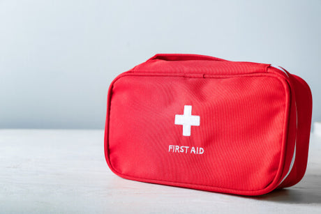 A red first aid kit on a table