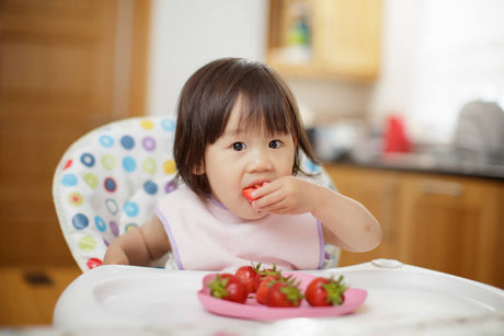 A little girl eating strawberries